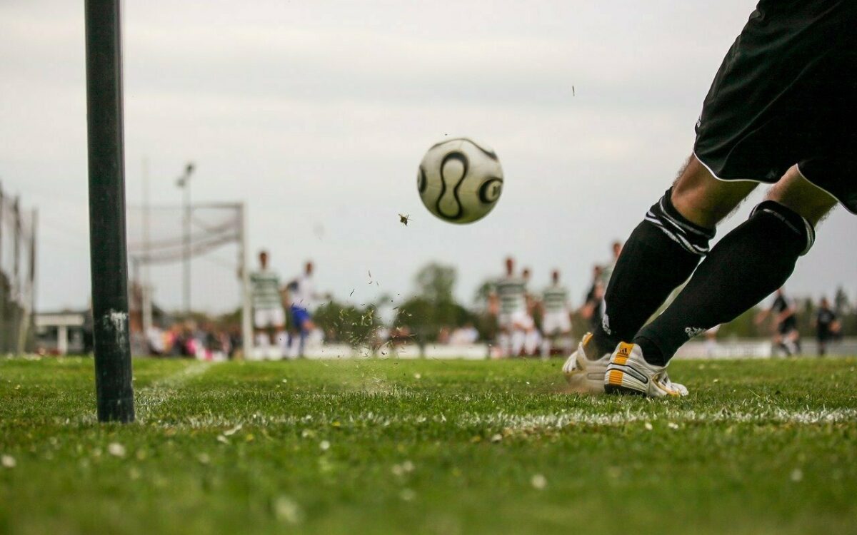Eine Ecke wird auf einem Fußballfeld in den Strafraum geschlagen Eine Ecke wird auf einem Fußballfeld in den Strafraum geschlagen